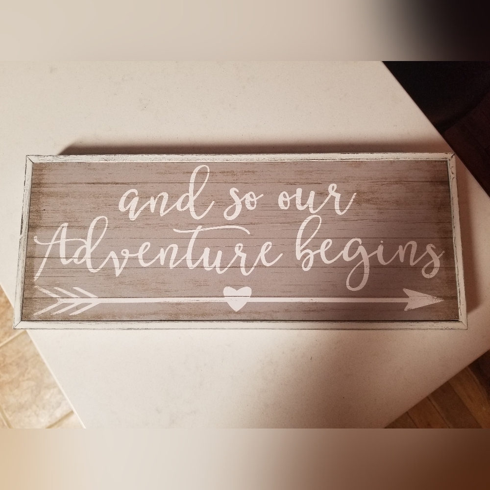 "And So Our Adventure Begins" sign